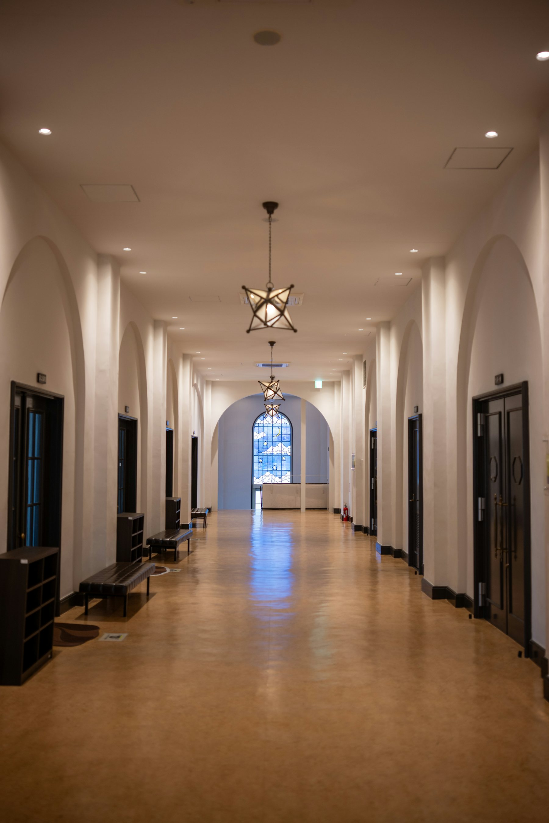 A tall arched hall with a line of lights receding into the distance