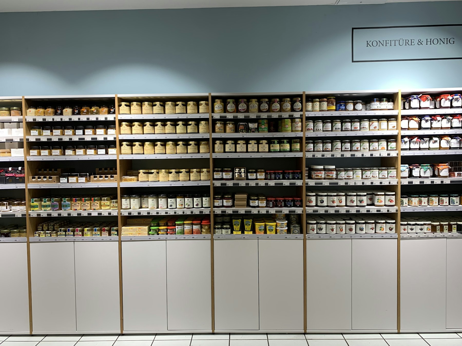 A dispensary wall of cream cabinetry against a muted sage ground