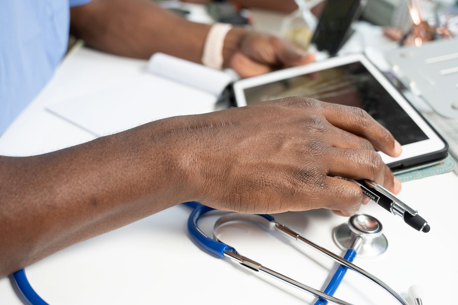 A clinician reviewing a tablet beside a stethoscope